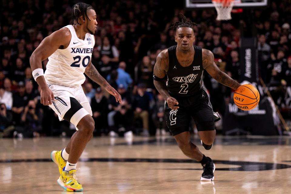 Bearcats guard Jizzle James (2) drives against Xavier's Dayvion McKnight Saturday. UC won 68-65 despite James missing all 11 of his shots from the field and scoring on only two free throws.