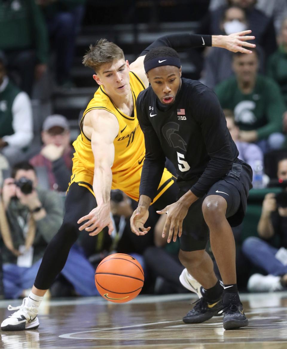 Oakland Golden Grizzlies guard Blake Lampman (11) defends against Michigan State Spartans guard Tre Holloman (5) during first half action Wednesday, December 21, 2022.