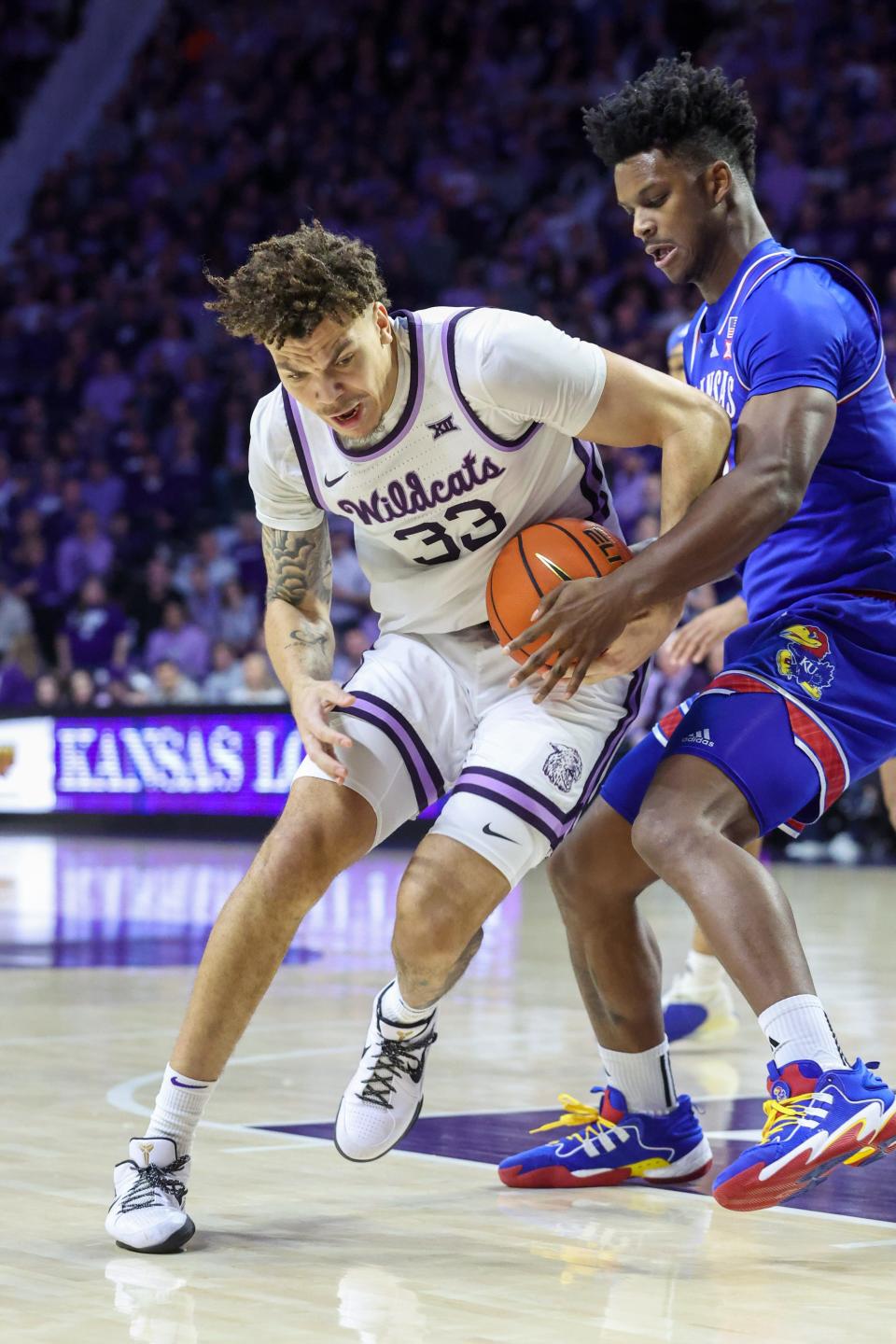 Kansas State forward Coleman Hawkins (33) tries to shield the ball from Kansas' KJ Adams during Saturday's Sunflower Showdown in Bramlage Coliseum.